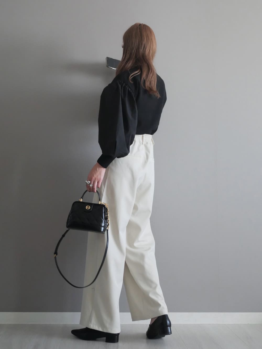 ブラック系のトートバッグ、ブラック系のニット/セーター、ブラック系のパンプスを着用したレディースの秋コーディネートの4枚目の写真