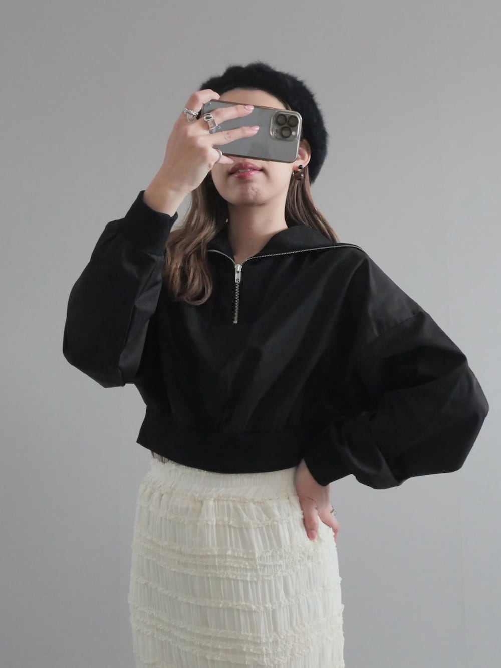 ブラック系のセットアップ、ホワイト系のスカート、ブラック系のショルダーバッグを着用したレディースの冬コーディネートの2枚目の写真