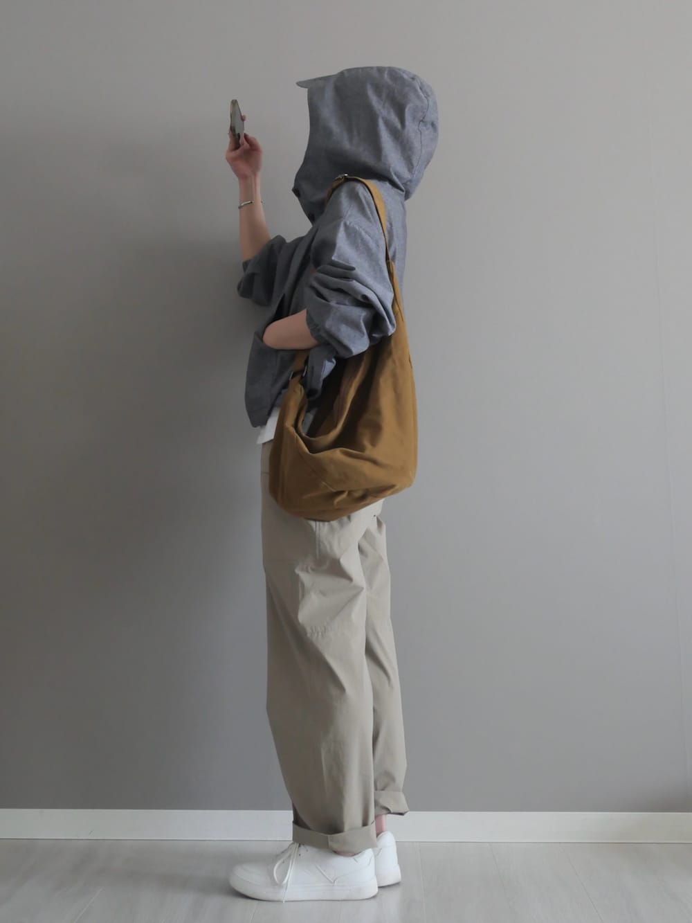 グレー系のシャツ/ブラウス、グリーン系のショルダーバッグ、ベージュ系のパンツを着用したレディースの春コーディネートの3枚目の写真