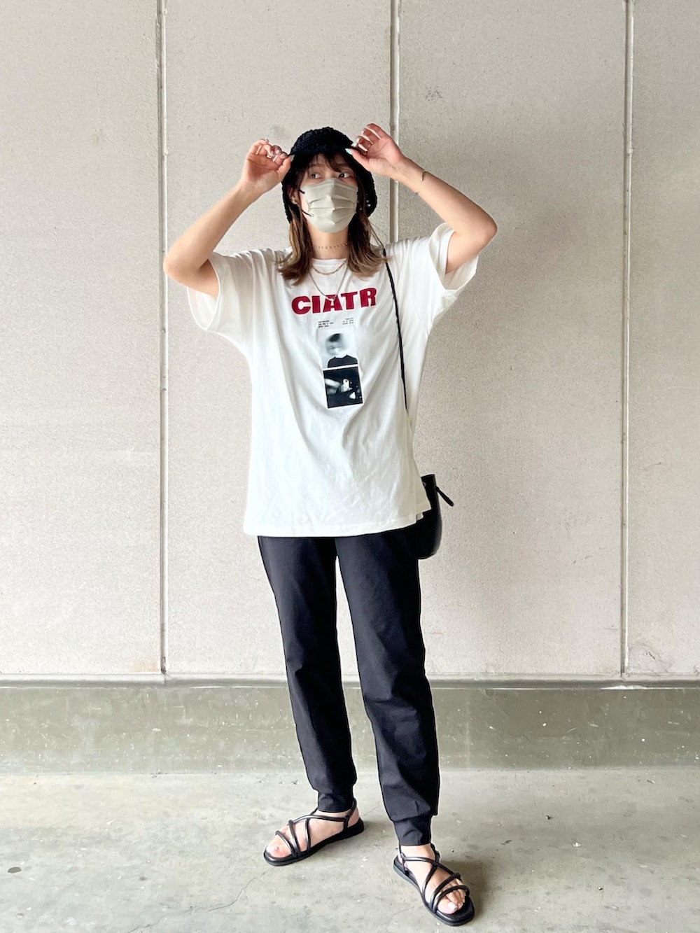 ホワイト系のTシャツ/カットソー、ブラック系のパンツ、ブラック系のバッグを着用したレディースの春コーディネートの2枚目の写真