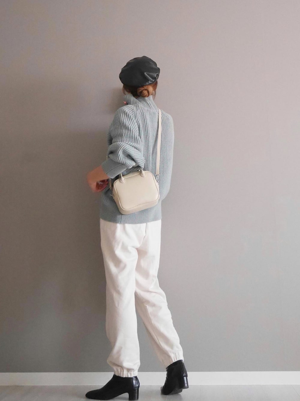 ブルー系のニット/セーター、ホワイト系のボストンバッグ、ホワイト系のパンツを着用したレディースの秋コーディネートの2枚目の写真