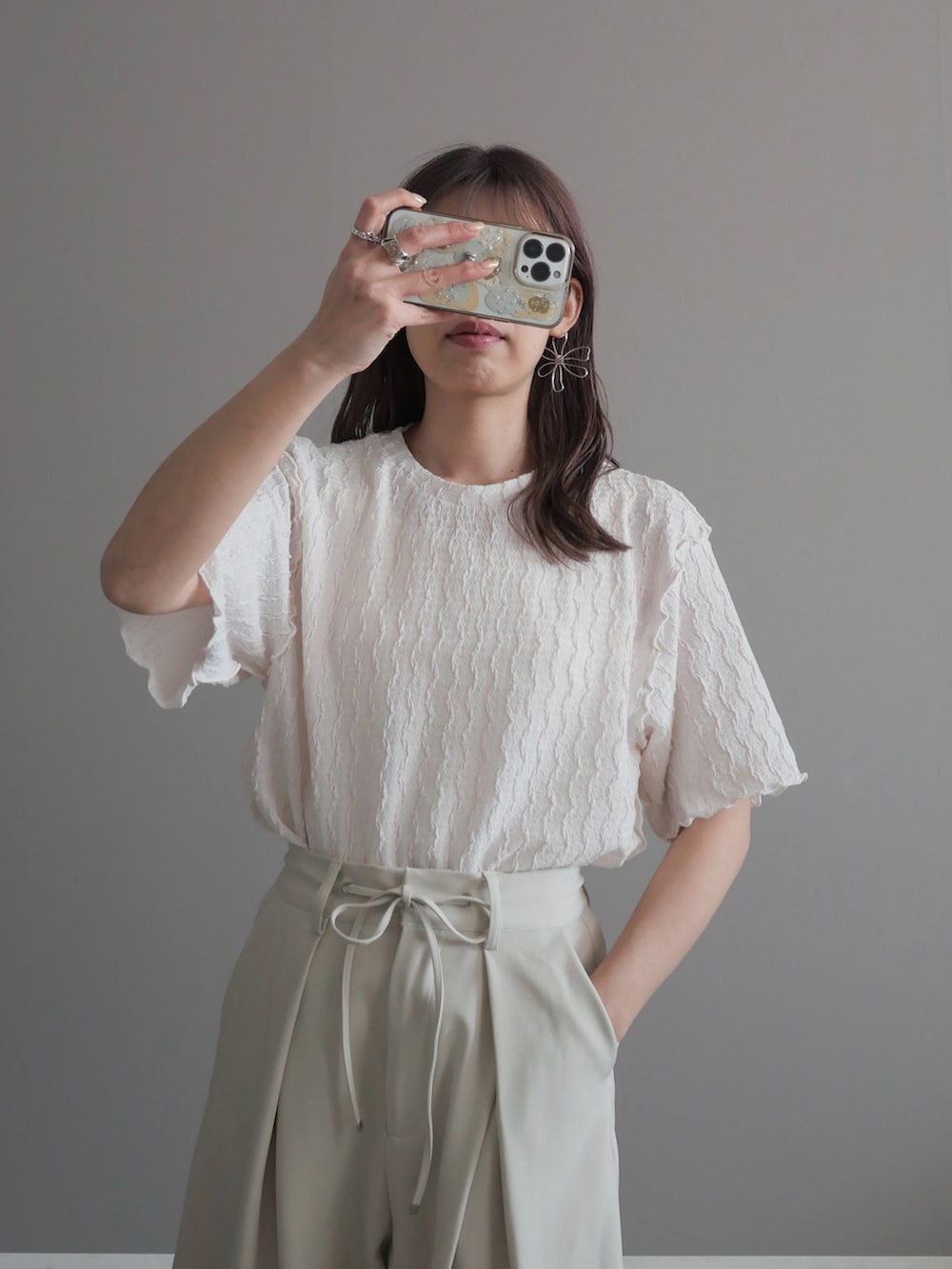 ホワイト系のスラックス、ホワイト系のパンプス、ホワイト系のTシャツ/カットソーを着用したレディースの春コーディネートの2枚目の写真