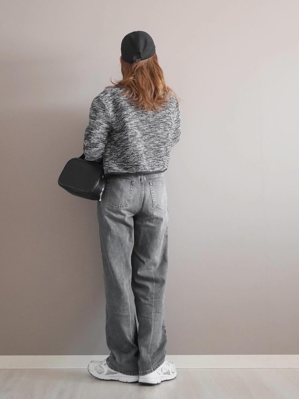 ブラック系のノーカラージャケット、ホワイト系のTシャツ/カットソー、グレー系のデニムパンツを着用したレディースの冬コーディネートの3枚目の写真