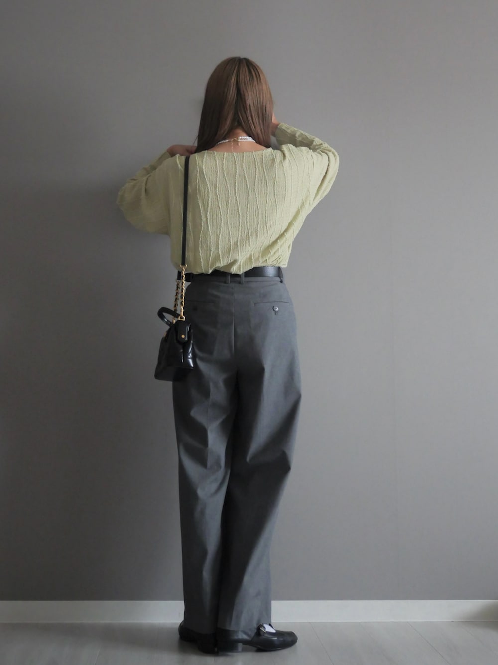 ブラック系のトートバッグ、グリーン系のTシャツ/カットソー、ブラック系のパンプスを着用したレディースの秋コーディネートの5枚目の写真