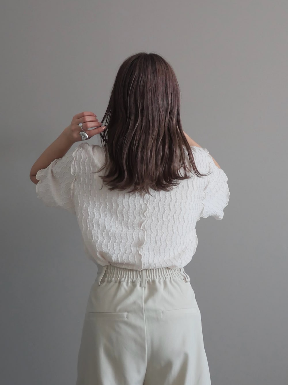 ホワイト系のスラックス、ホワイト系のパンプス、ホワイト系のTシャツ/カットソーを着用したレディースの春コーディネートの3枚目の写真