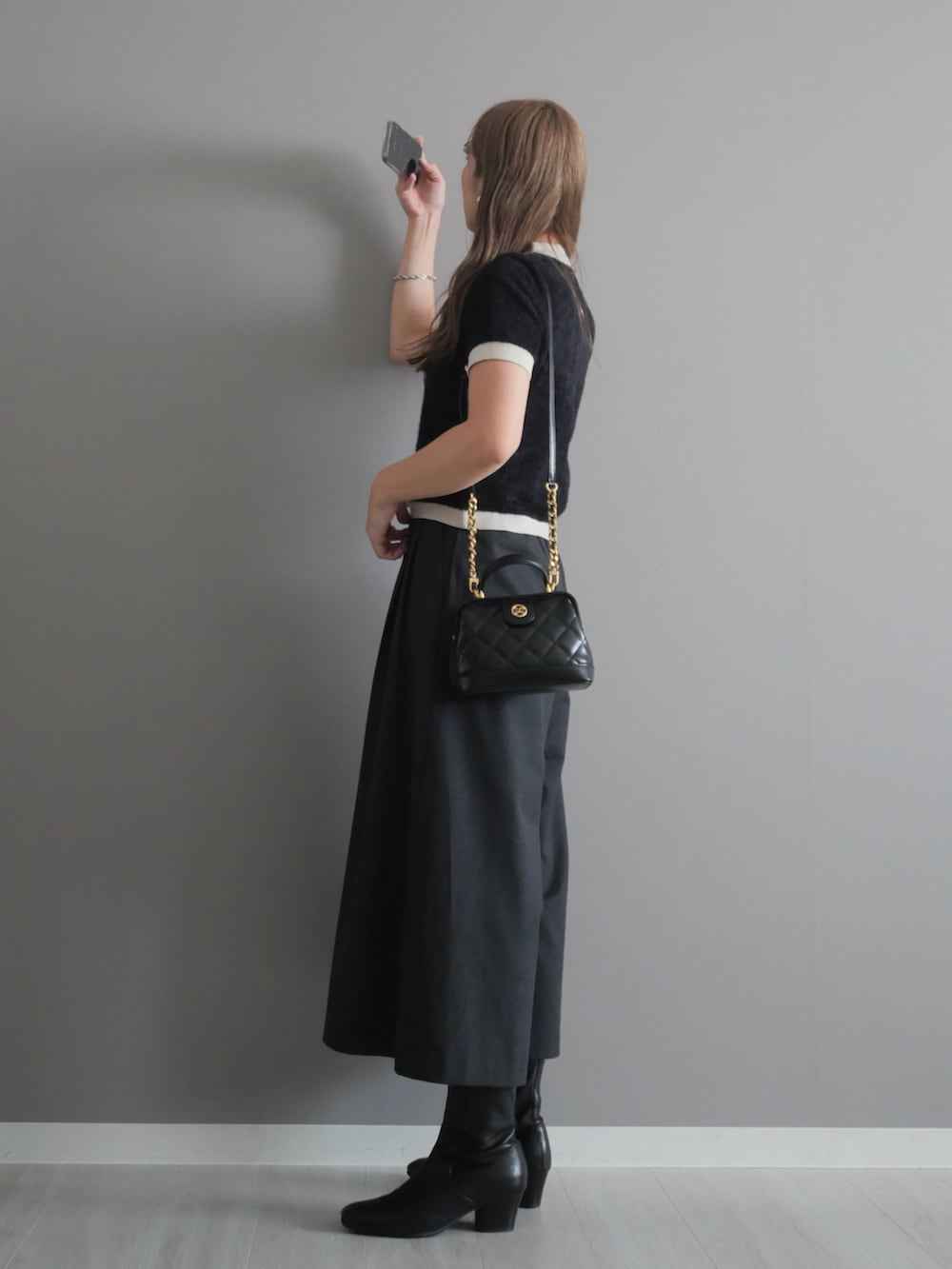 ブラック系のトートバッグ、ブラック系のブーツ、ブラック系のニット/セーターを着用したレディースの秋コーディネートの4枚目の写真