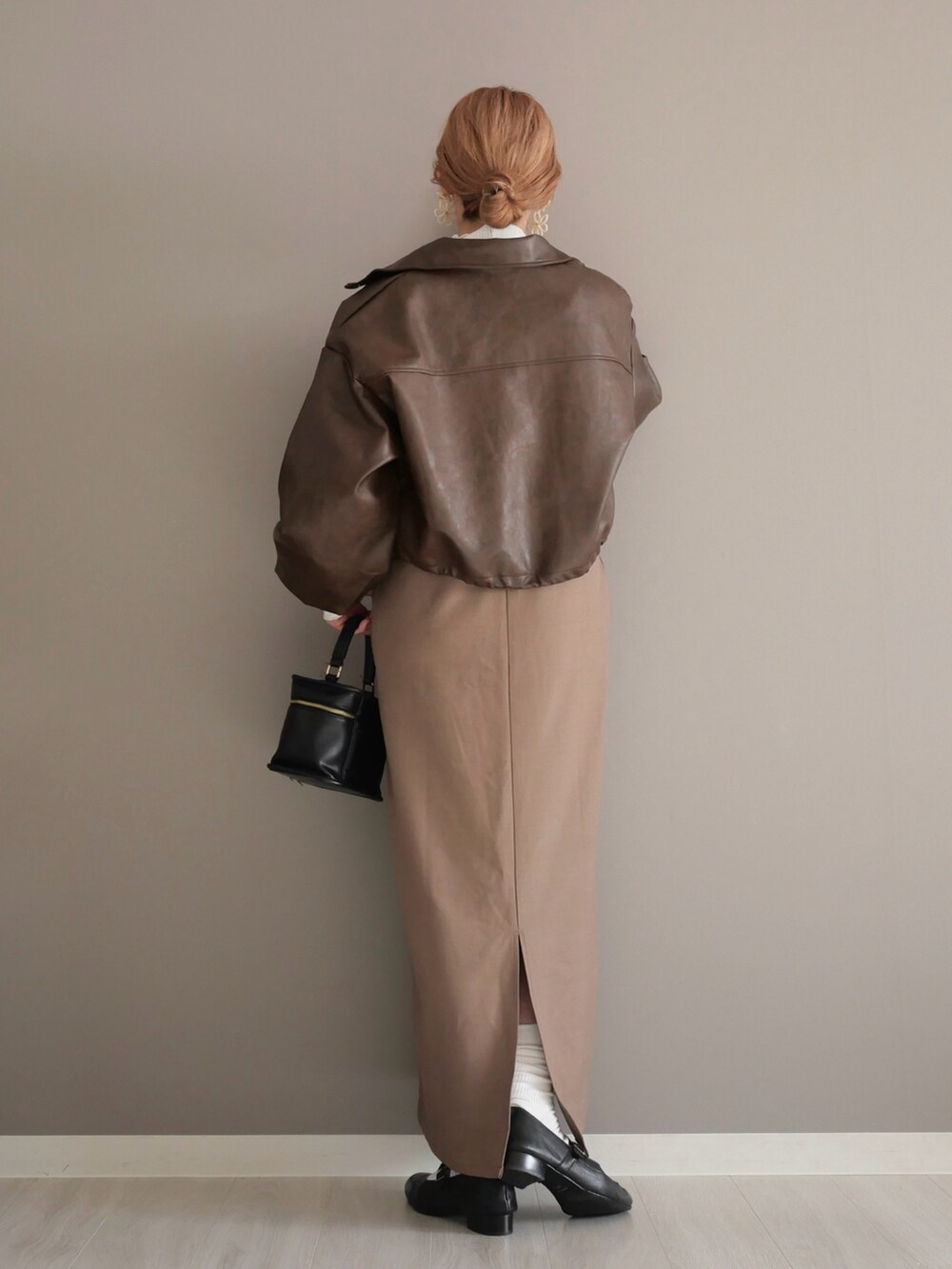 ブラウン系のブルゾン、ホワイト系のTシャツ/カットソー、ベージュ系のワンピースを着用したレディースの秋コーディネートの5枚目の写真