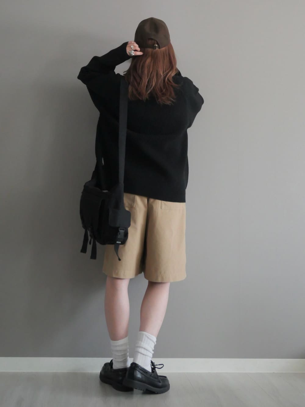 ブラック系のショルダーバッグ、ブラック系のニット/セーター、ブラック系のモカシン/デッキシューズを着用したレディースの秋コーディネートの4枚目の写真