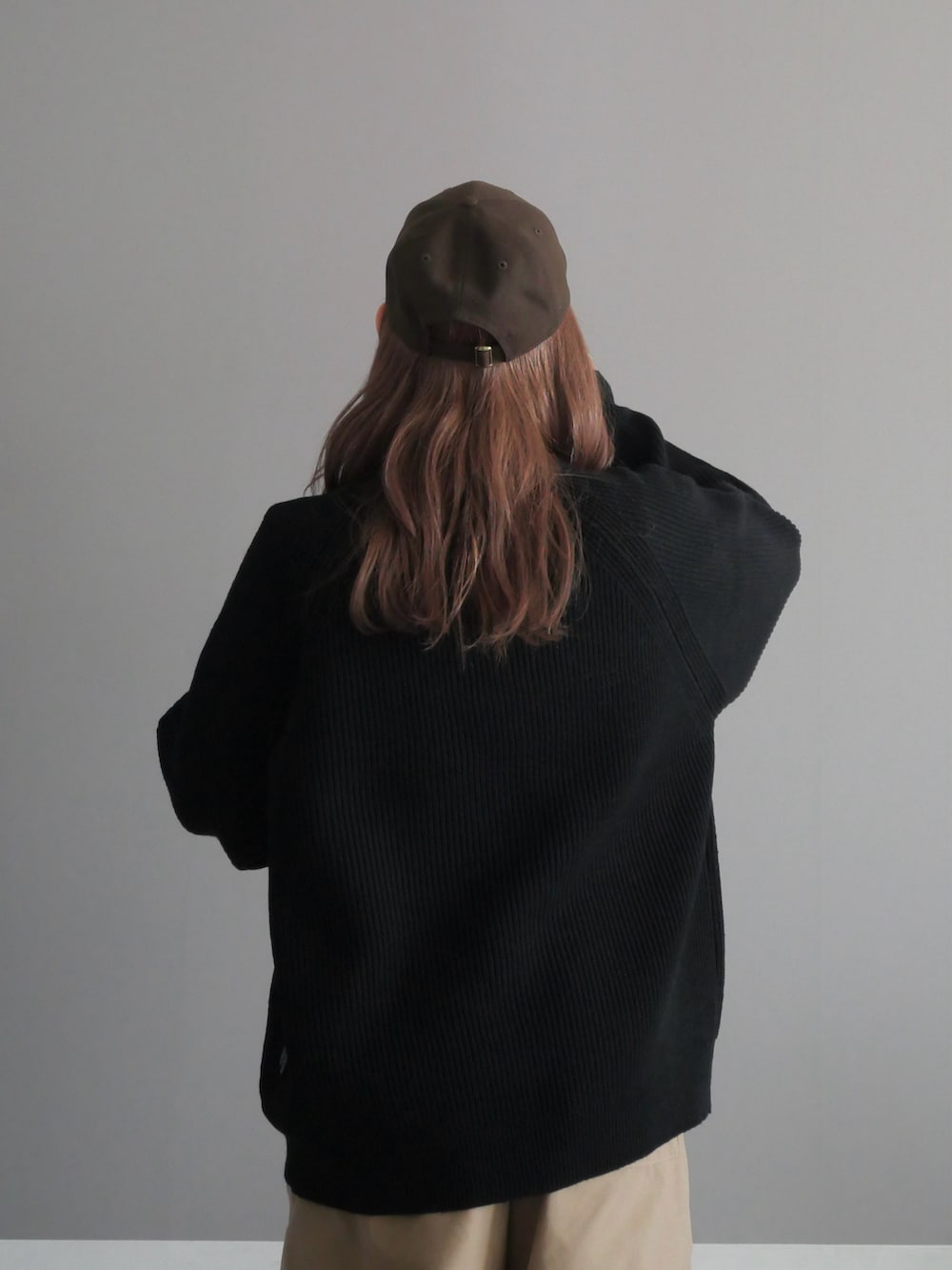 ブラック系のショルダーバッグ、ブラック系のニット/セーター、ブラック系のモカシン/デッキシューズを着用したレディースの秋コーディネートの5枚目の写真