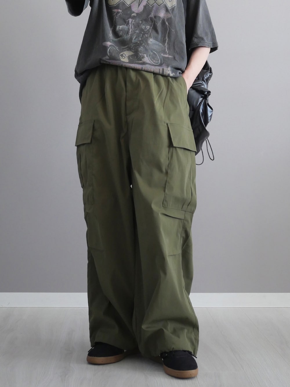 グレー系のTシャツ/カットソー、グリーン系のカーゴパンツ、ブラック系のバックパック/リュックを着用したレディースの春コーディネートの5枚目の写真