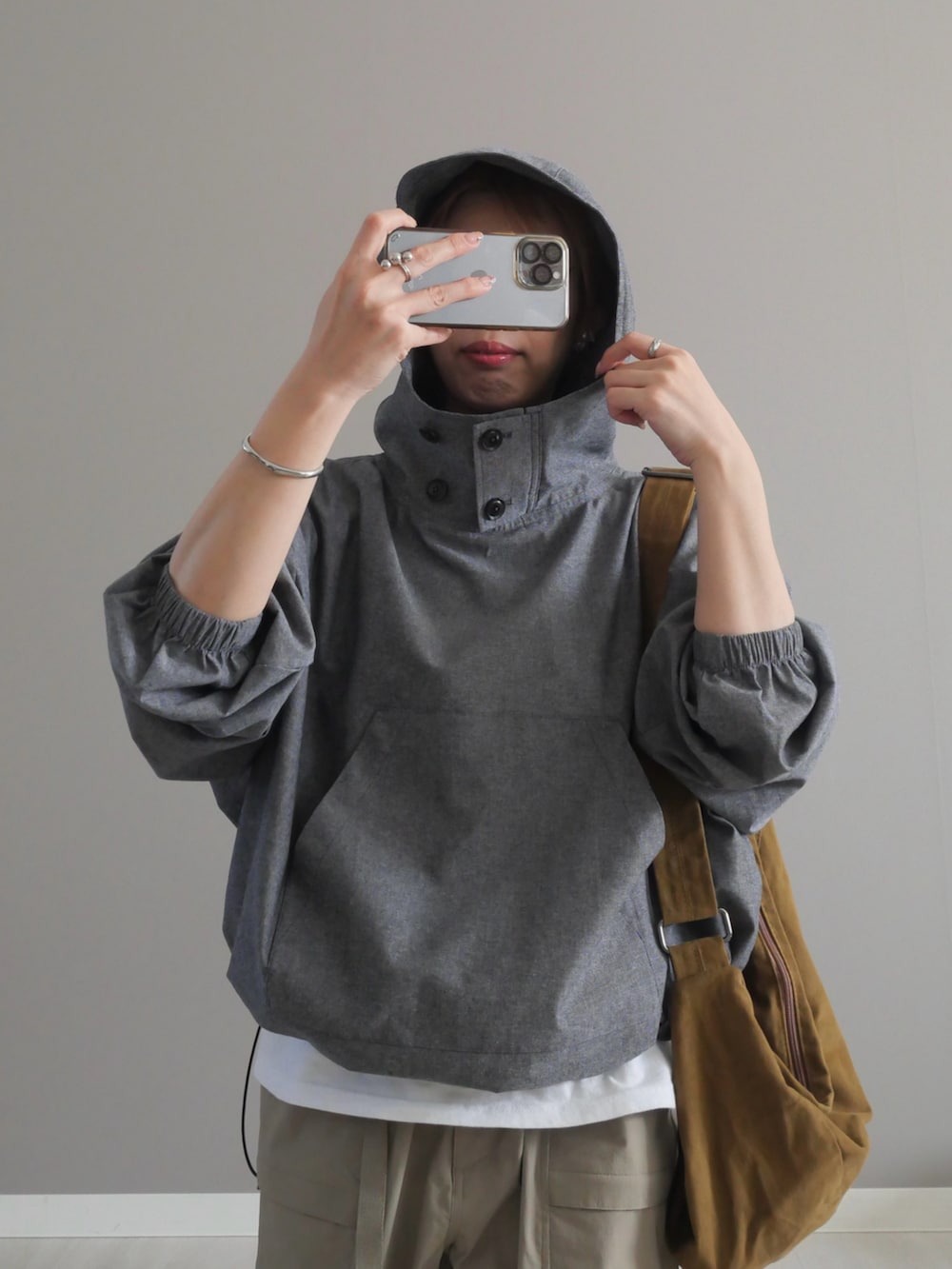 グレー系のシャツ/ブラウス、グリーン系のショルダーバッグ、ベージュ系のパンツを着用したレディースの春コーディネートの4枚目の写真