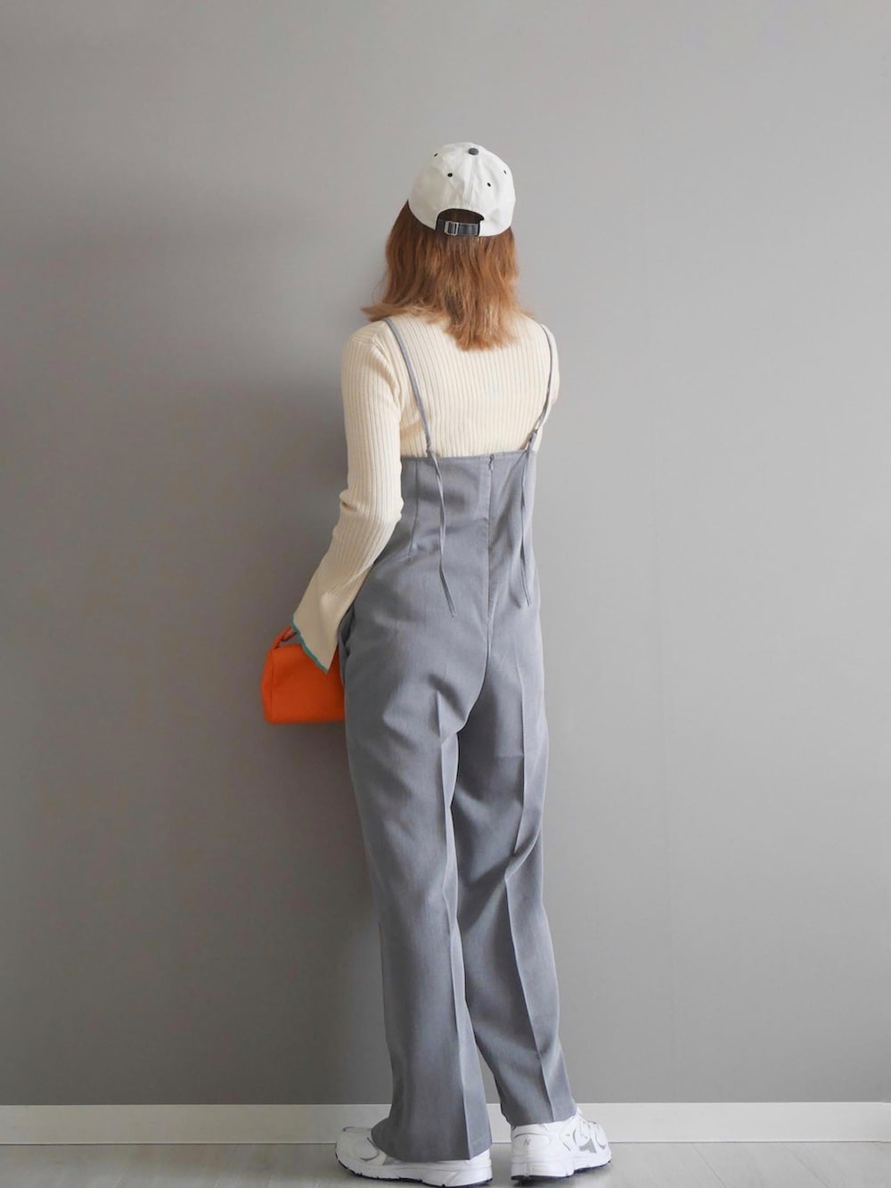 グレー系のつなぎ/オールインワン、ホワイト系のニット/セーター、ホワイト系のスニーカーを着用したレディースの春コーディネートの2枚目の写真