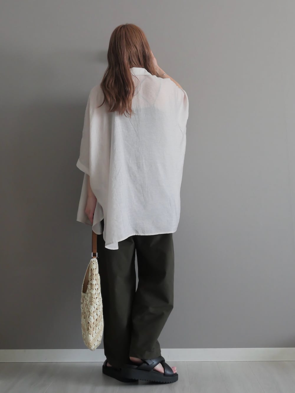 グレー系のシャツ/ブラウス、ベージュ系のかごバッグ、グリーン系のパンツを着用したレディースの春コーディネートの4枚目の写真