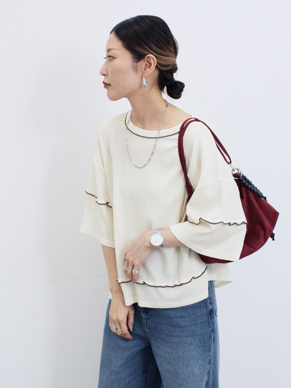 ホワイト系のTシャツ/カットソー、ブルー系のその他パンツ、レッド系のハンドバッグを着用したレディースの秋コーディネートの3枚目の写真