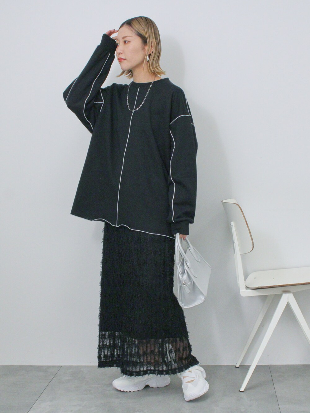 ブラック系のTシャツ/カットソー、シルバー系のハンドバッグ、ホワイト系のドレスシューズを着用したレディースの冬コーディネートの2枚目の写真