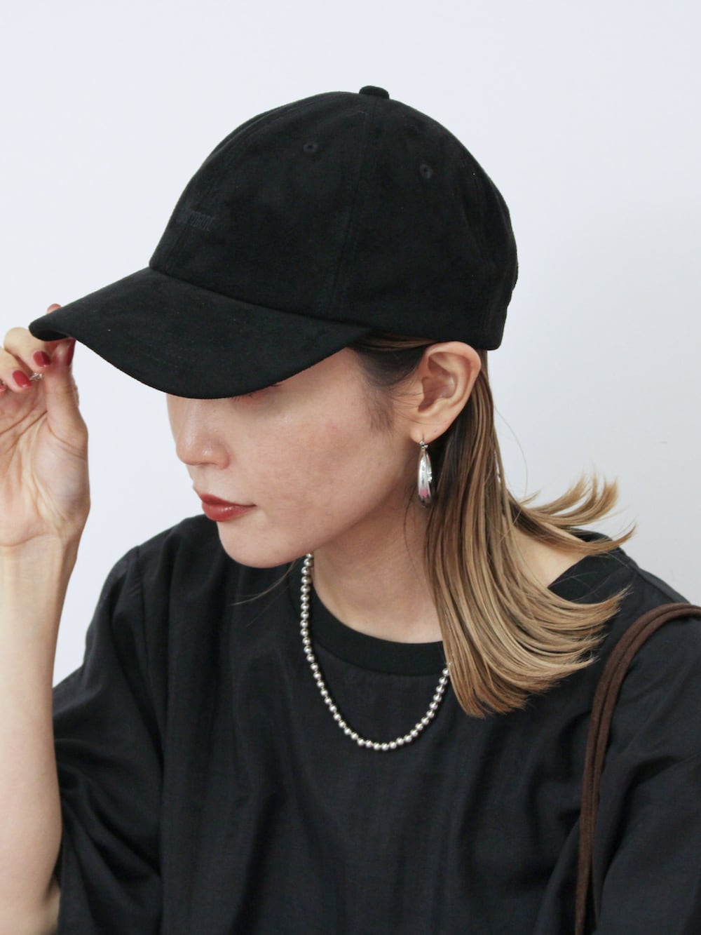 ブラック系のTシャツ/カットソー、ブラック系のスカート、ブラウン系のハンドバッグを着用したレディースの秋コーディネートの4枚目の写真