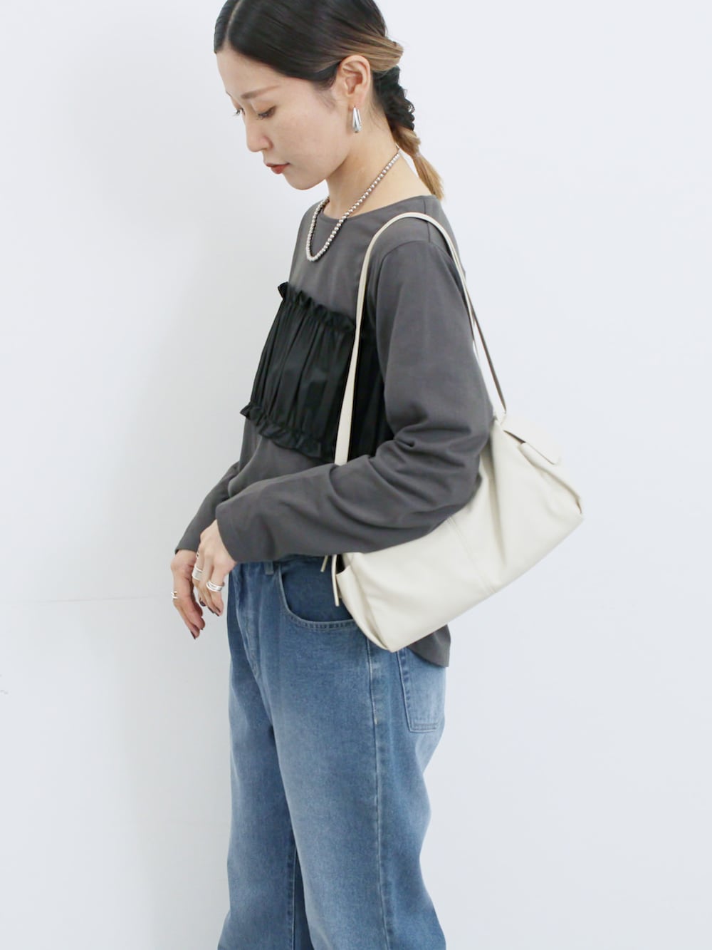 ブラック系のスニーカー、グレー系のTシャツ/カットソー、ブルー系のその他パンツを着用したレディースの秋コーディネートの3枚目の写真