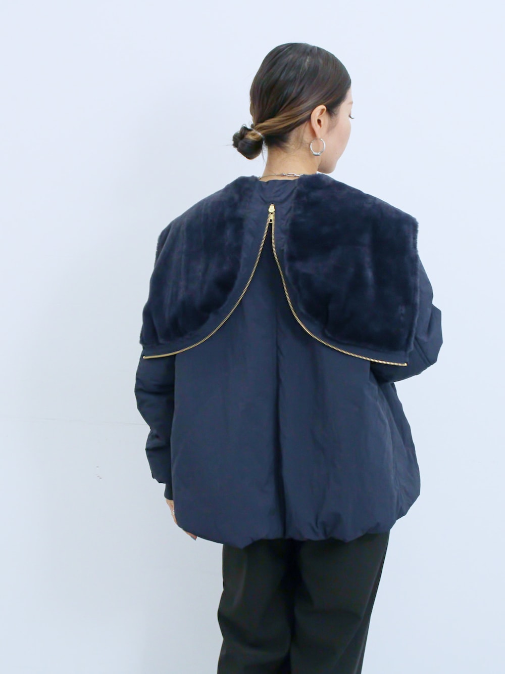 ブラック系のスニーカー、グレー系のニット/セーター、ブルー系のノーカラージャケットを着用したレディースの冬コーディネートの3枚目の写真