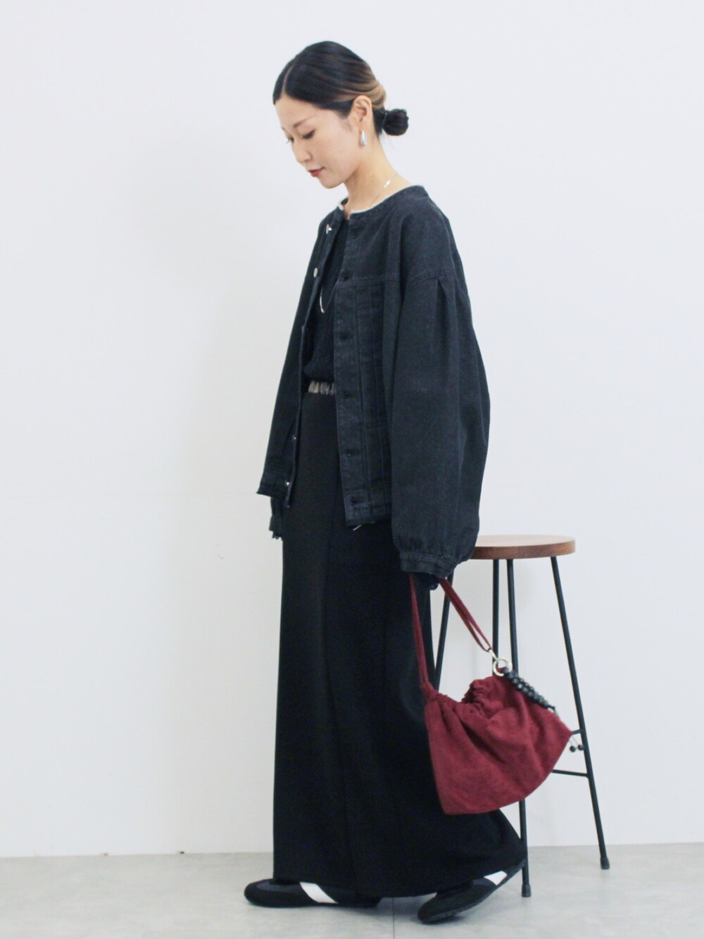 グレー系のブルゾン、ブラック系のスカート、ブラック系のTシャツ/カットソーを着用したレディースの秋コーディネートの2枚目の写真