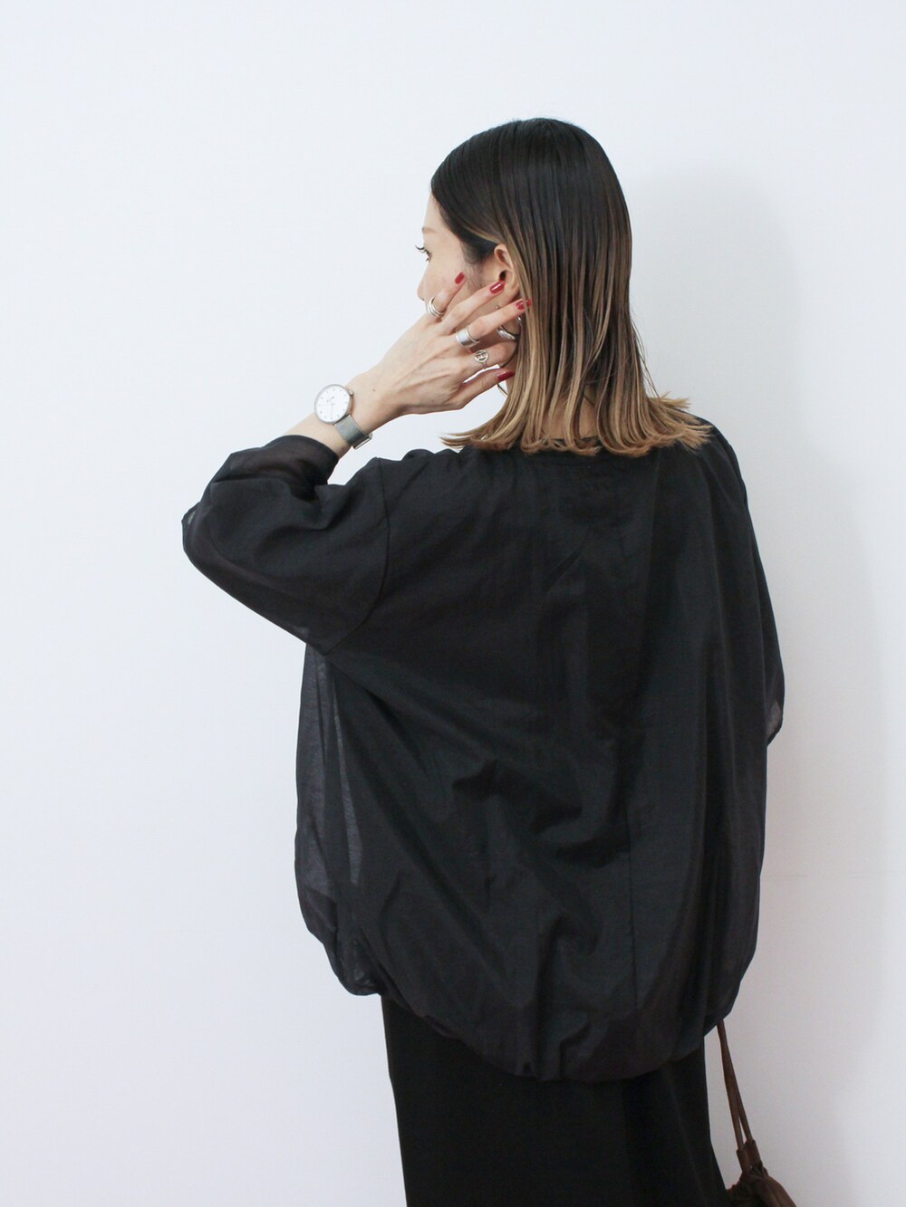 ブラック系のTシャツ/カットソー、ブラック系のスカート、ブラウン系のハンドバッグを着用したレディースの秋コーディネートの3枚目の写真