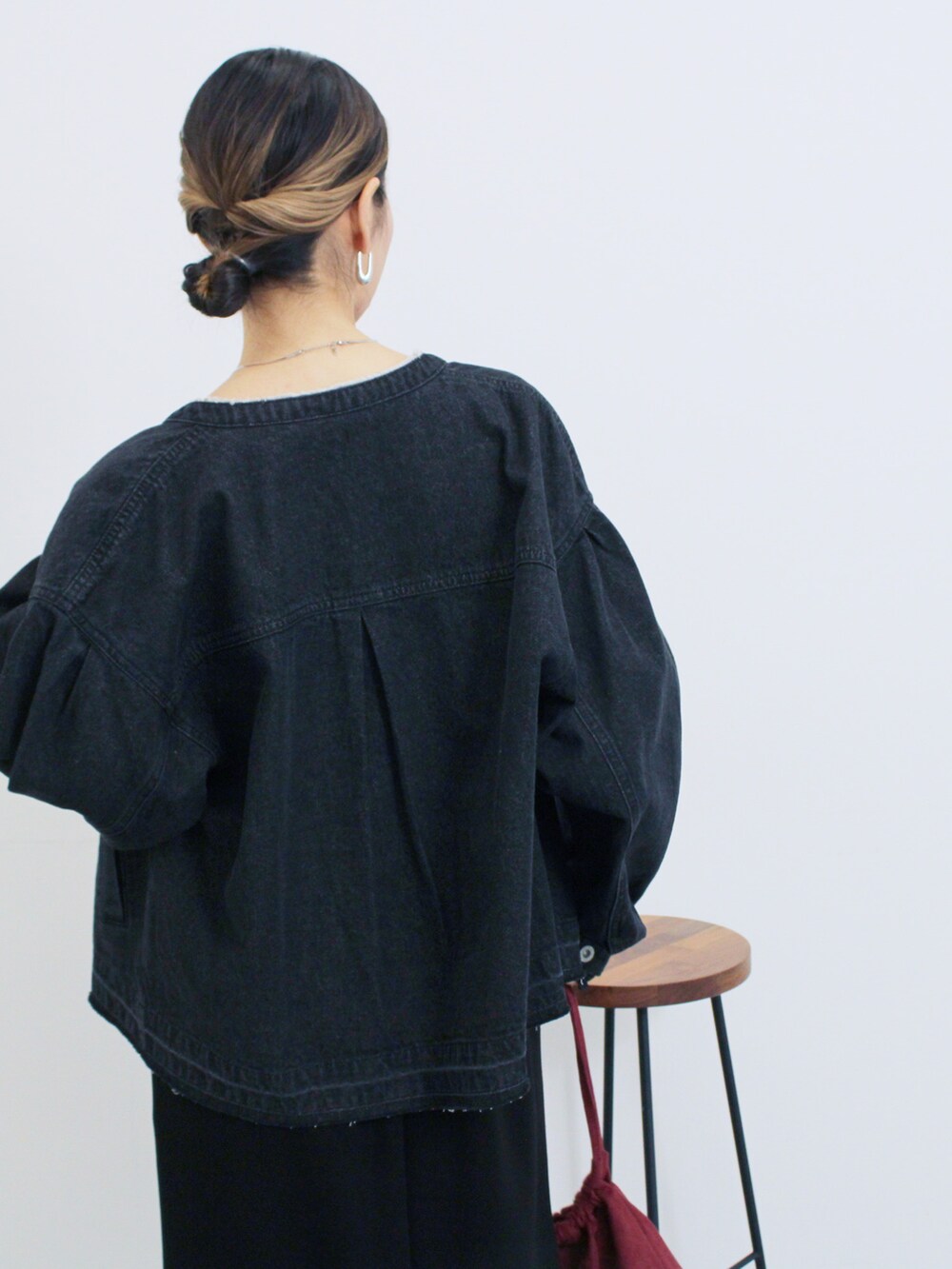 グレー系のブルゾン、ブラック系のスカート、ブラック系のTシャツ/カットソーを着用したレディースの秋コーディネートの3枚目の写真