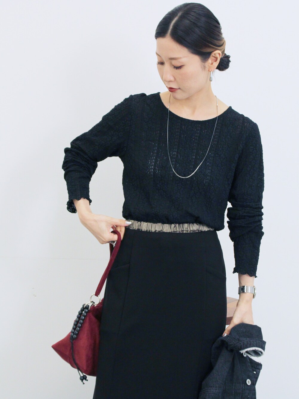 グレー系のブルゾン、ブラック系のスカート、ブラック系のTシャツ/カットソーを着用したレディースの秋コーディネートの4枚目の写真