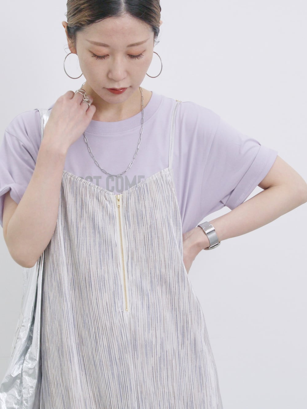 グレー系のワンピース、パープル系のTシャツ/カットソー、シルバー系のハンドバッグを着用したレディースの春コーディネートの4枚目の写真