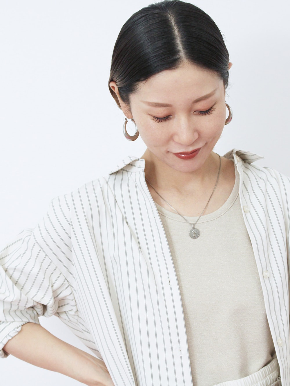 ブラウン系のハンドバッグ、シルバー系のドレスシューズ、ホワイト系のシャツ/ブラウスを着用したレディースの秋コーディネートの3枚目の写真