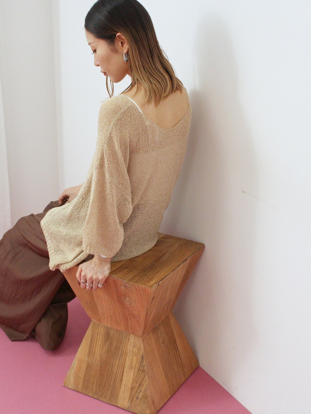 ベージュ系のニット/セーター、ブラウン系のその他パンツ、ブラウン系のハンドバッグを着用したレディースの秋コーディネートの2枚目の写真