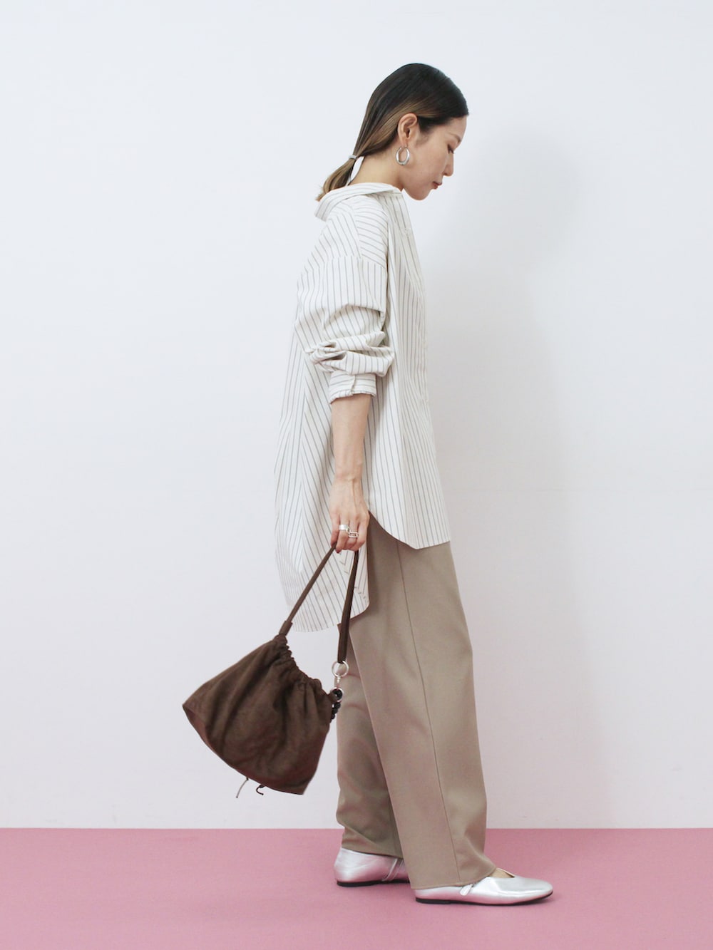 ブラウン系のハンドバッグ、シルバー系のドレスシューズ、ホワイト系のシャツ/ブラウスを着用したレディースの秋コーディネートの2枚目の写真