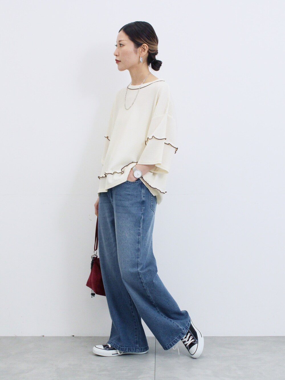 ホワイト系のTシャツ/カットソー、ブルー系のその他パンツ、レッド系のハンドバッグを着用したレディースの秋コーディネートの2枚目の写真