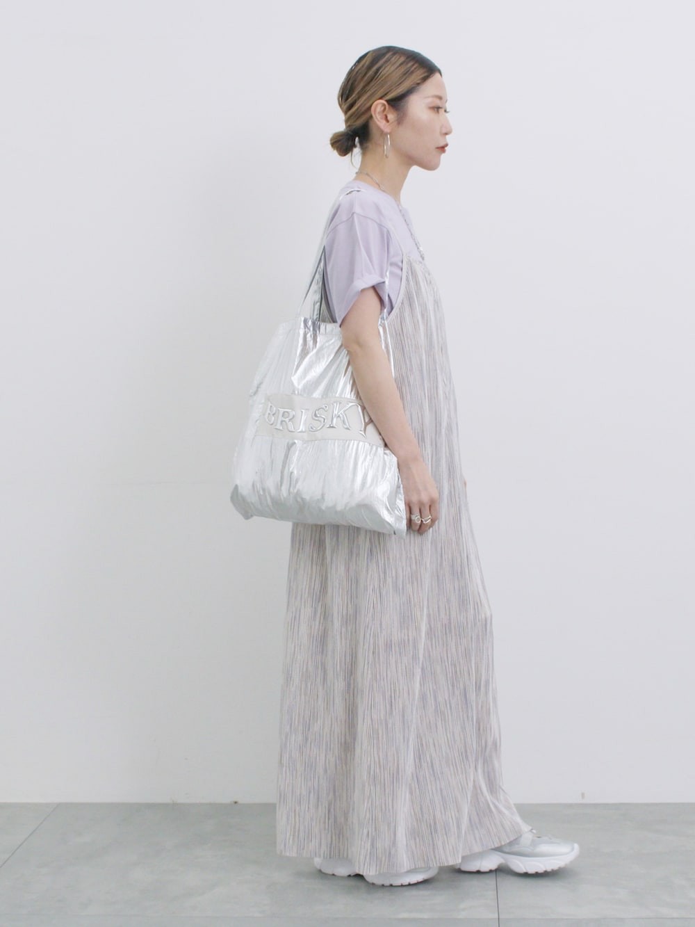 グレー系のワンピース、パープル系のTシャツ/カットソー、シルバー系のハンドバッグを着用したレディースの春コーディネートの2枚目の写真