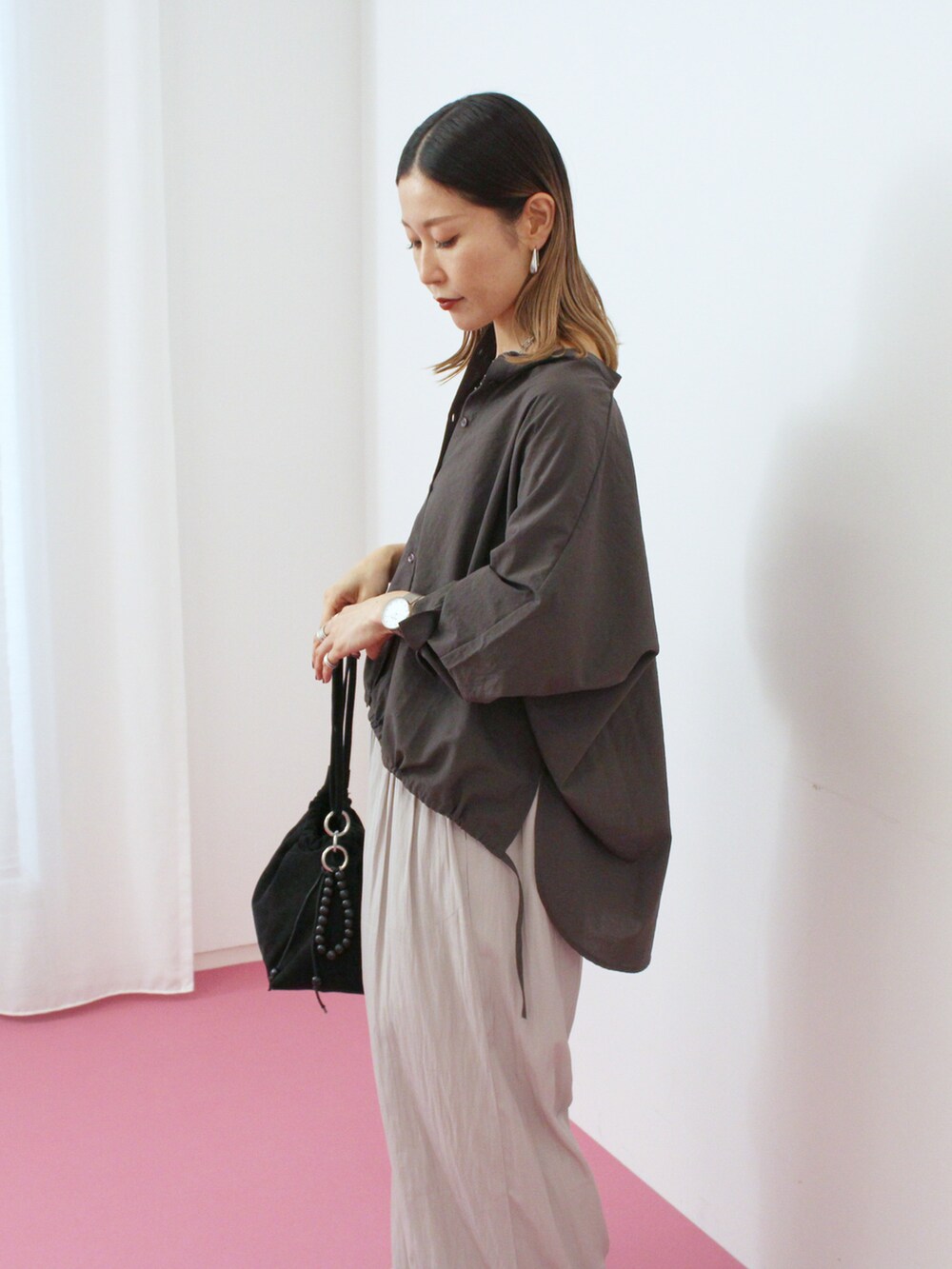 グレー系のシャツ/ブラウス、グレー系のその他パンツ、ブラック系のハンドバッグを着用したレディースの秋コーディネートの2枚目の写真