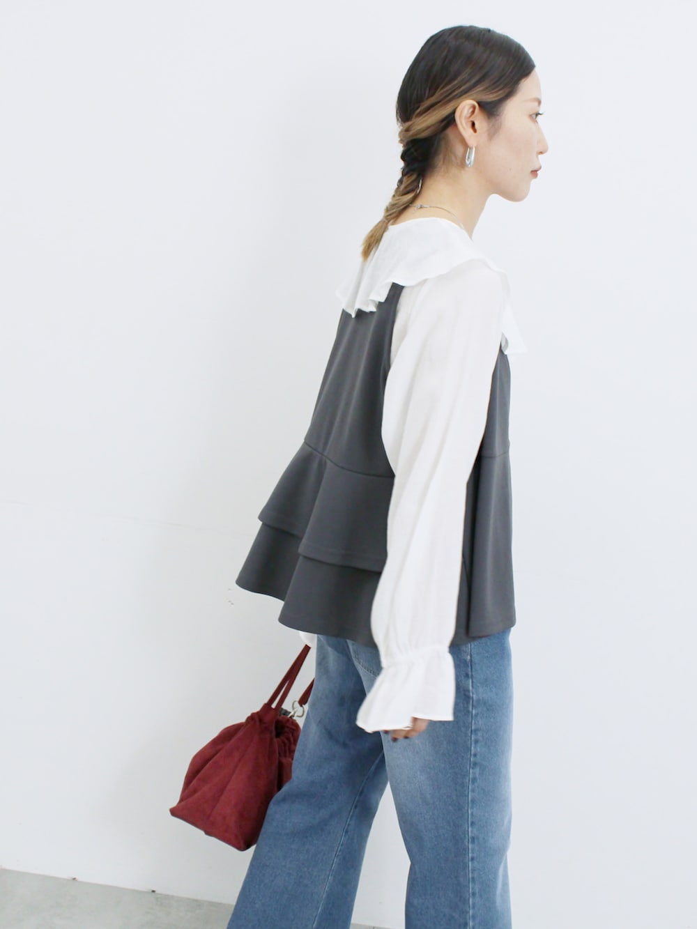 グレー系のベスト、ホワイト系のシャツ/ブラウス、ブルー系のその他パンツを着用したレディースの秋コーディネートの3枚目の写真