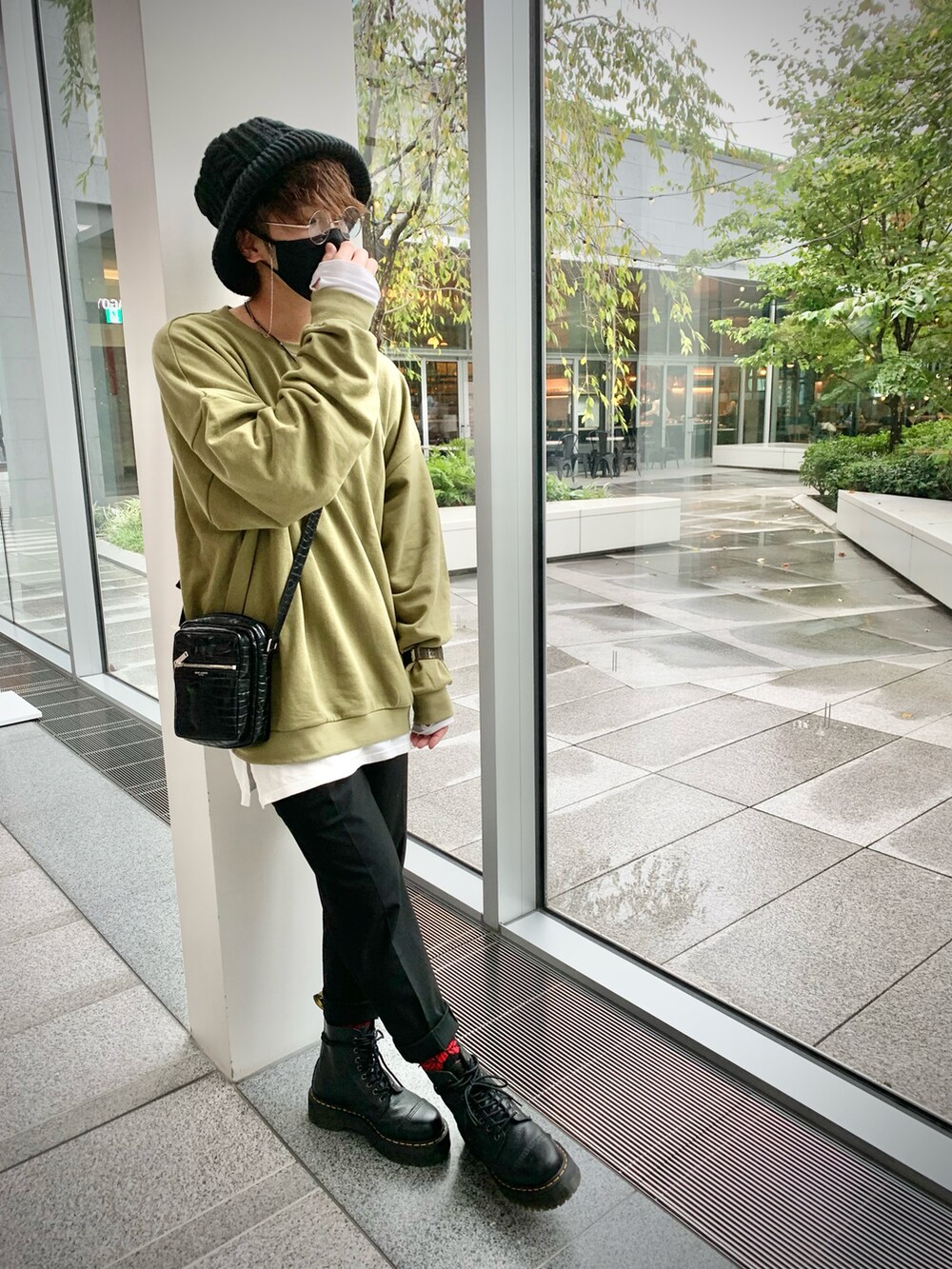 ブラック系のブーツ、グリーン系のスウェット、ブラック系のショルダーバッグを着用したメンズの秋コーディネートの2枚目の写真