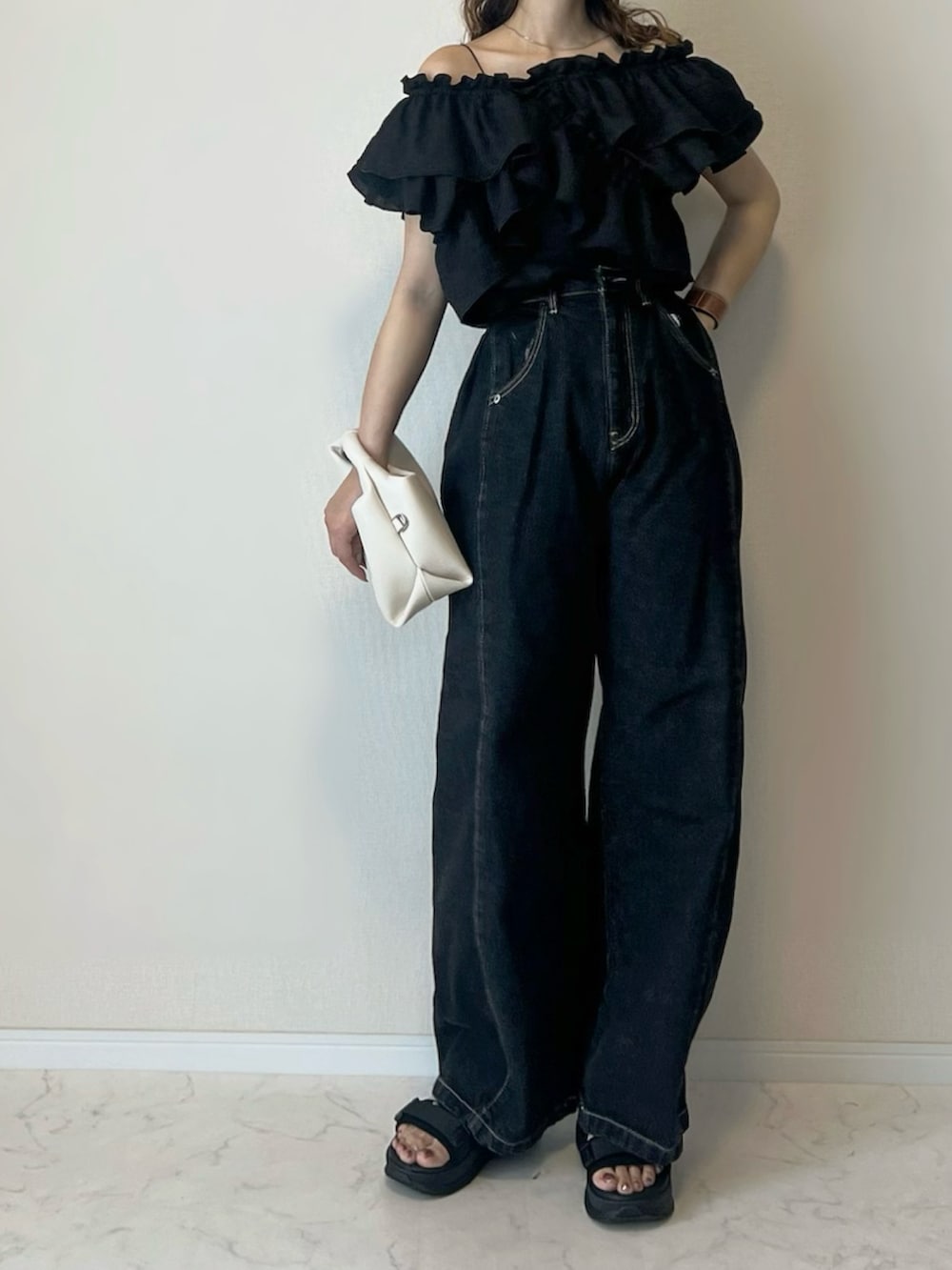 ブラック系のシャツ/ブラウス、ブラック系のデニムパンツ、ブラック系のサンダルを着用したレディースの春コーディネートの3枚目の写真