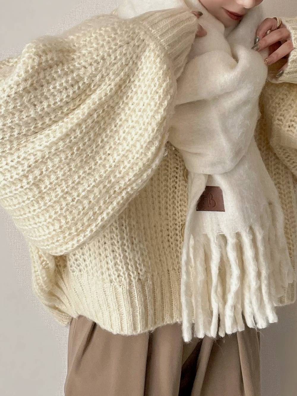 ホワイト系のカーディガン/ボレロ、ブラウン系のパンツ、ブラウン系のブーツを着用したレディースの秋コーディネートの4枚目の写真