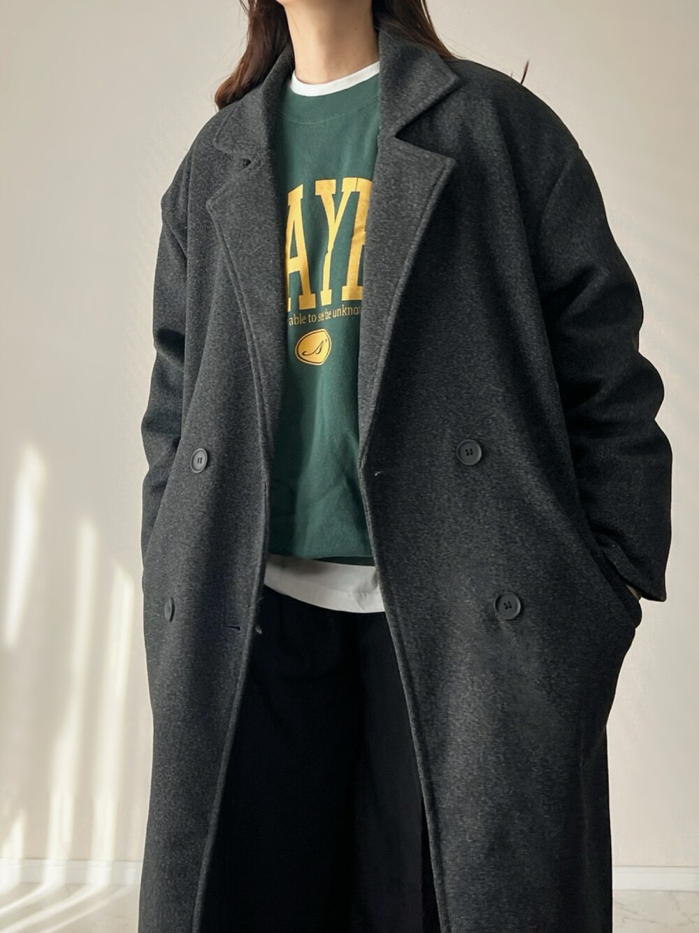 グレー系のチェスターコート、グリーン系のスウェットを着用したレディースの秋コーディネートの3枚目の写真