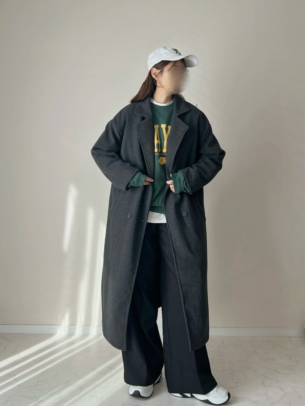 グレー系のチェスターコート、グリーン系のスウェットを着用したレディースの秋コーディネートの4枚目の写真