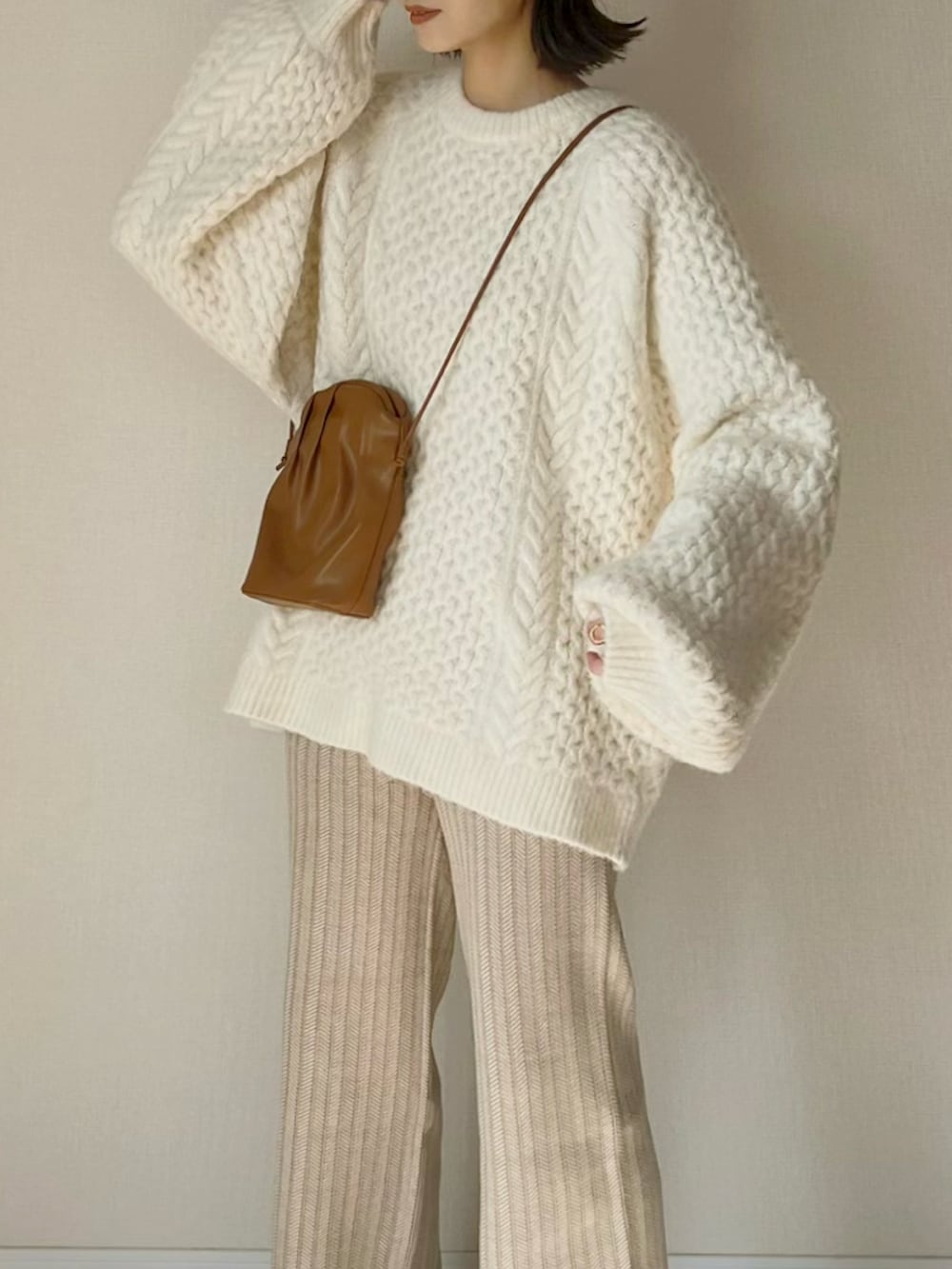 ベージュ系のその他パンツ、ホワイト系のニット/セーター、イエロー系のショルダーバッグを着用したレディースの秋コーディネートの2枚目の写真