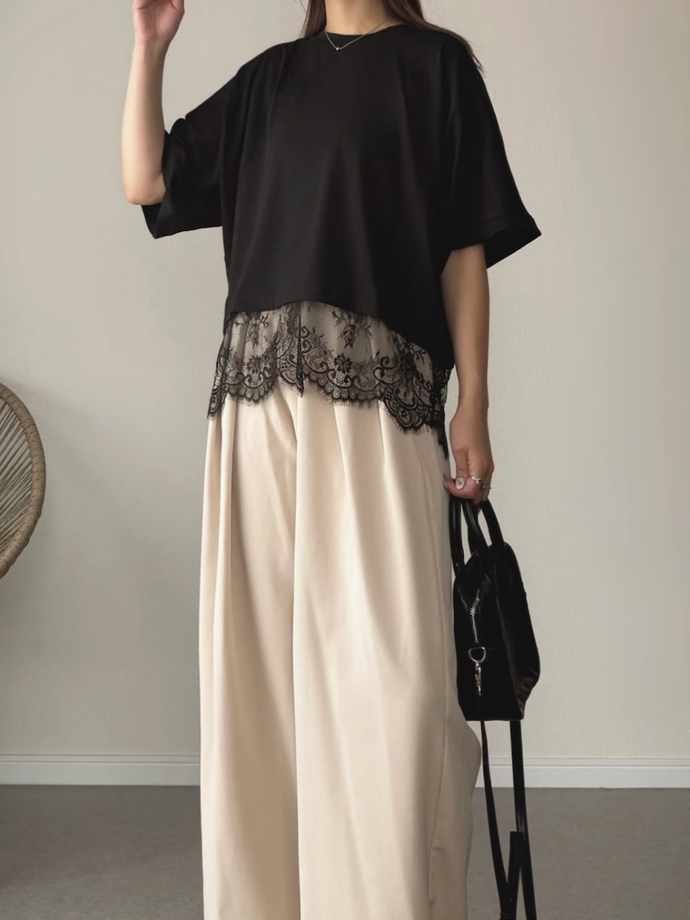 ブラック系のサンダル、ブラック系のTシャツ/カットソー、ホワイト系のスラックスを着用したレディースの夏コーディネートの2枚目の写真
