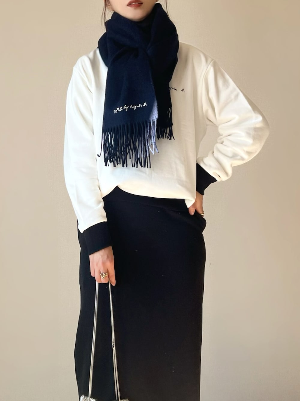 ホワイト系のスウェット、ブラック系のスカート、ホワイト系のスニーカーを着用したレディースの秋コーディネートの3枚目の写真