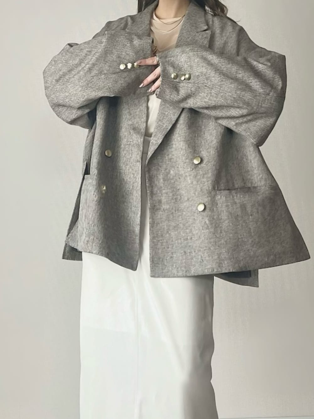 ベージュ系のテーラードジャケット、ホワイト系のスカート、ブラウン系のボストンバッグを着用したレディースの春コーディネートの4枚目の写真