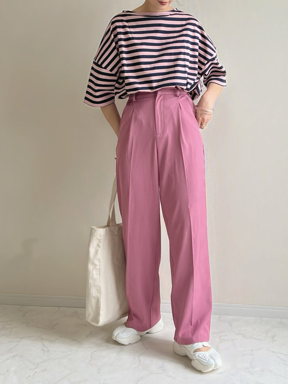 ピンク系のTシャツ/カットソー、ピンク系のスラックス、ホワイト系のスニーカーを着用したレディースの春コーディネートの2枚目の写真