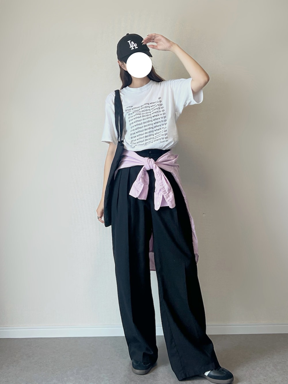 ブラック系のスニーカー、ホワイト系のTシャツ/カットソー、ブラック系のスラックスを着用したレディースの夏コーディネートの2枚目の写真