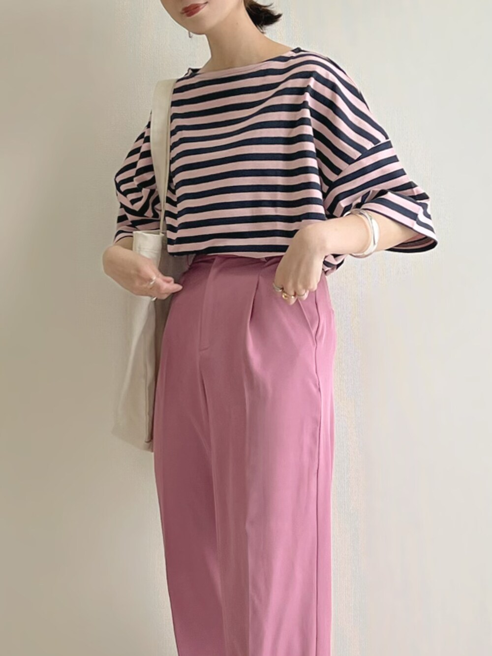 ピンク系のTシャツ/カットソー、ピンク系のスラックス、ホワイト系のスニーカーを着用したレディースの春コーディネートの3枚目の写真