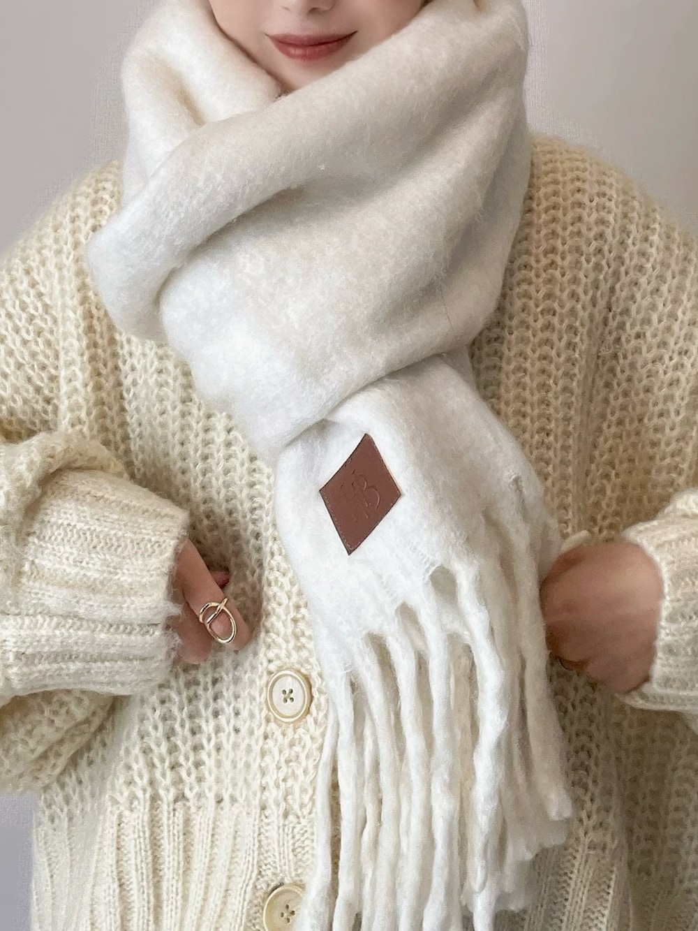 ホワイト系のカーディガン/ボレロ、ブラウン系のパンツ、ブラウン系のブーツを着用したレディースの秋コーディネートの3枚目の写真