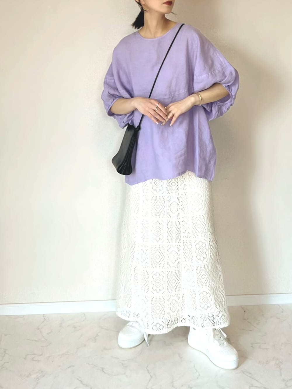 パープル系のシャツ/ブラウス、ホワイト系のスカート、ホワイト系のスニーカーを着用したレディースの春コーディネートの2枚目の写真