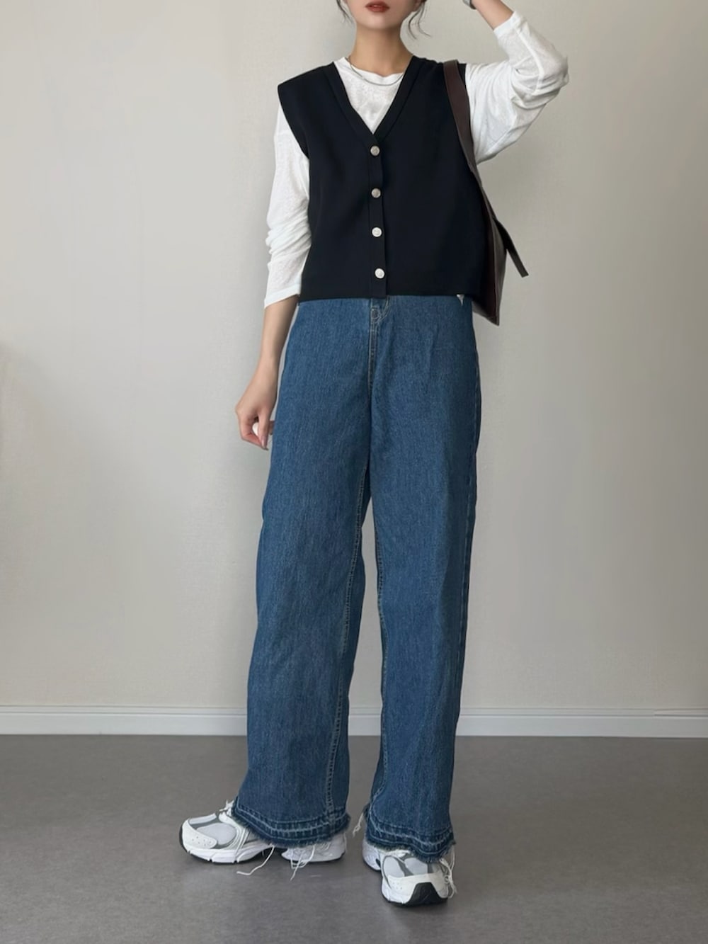 ブラック系のベスト、ホワイト系のTシャツ/カットソー、ブルー系のデニムパンツを着用したレディースの春コーディネートの3枚目の写真