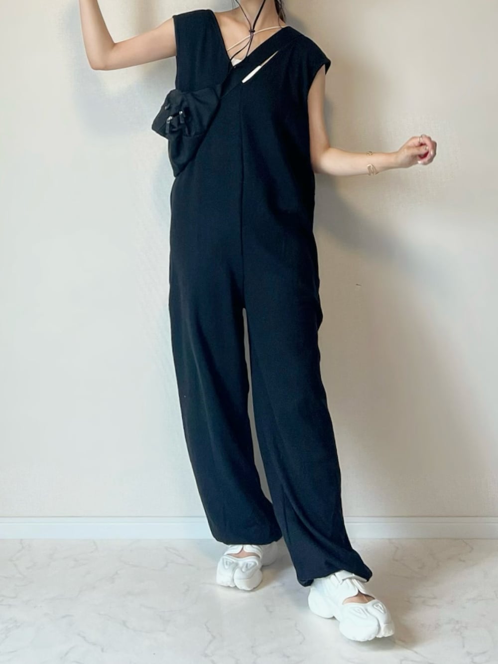 ブラック系のサロペット/オーバーオール、ホワイト系のスニーカー、ブラック系のボディバッグ/ウエストポーチを着用したレディースの夏コーディネートの2枚目の写真